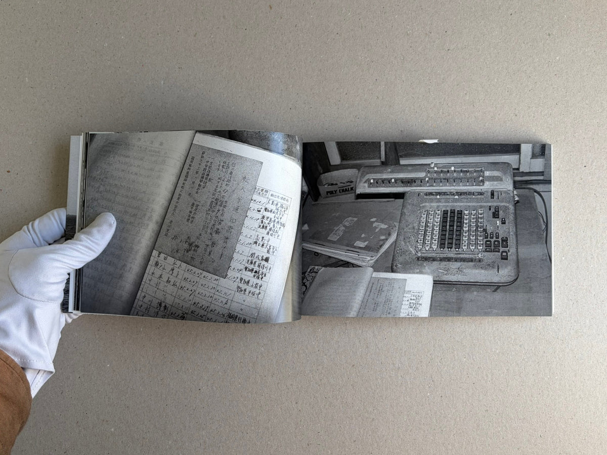 Open spread of Hashima - Taiji Matsue showing black-and-white interior photographs with Japanese text pages and a hand holding the book