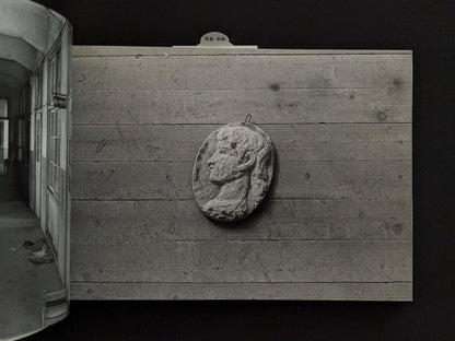 Wall-mounted sculpture of a head in the ruins of Hashima Island
