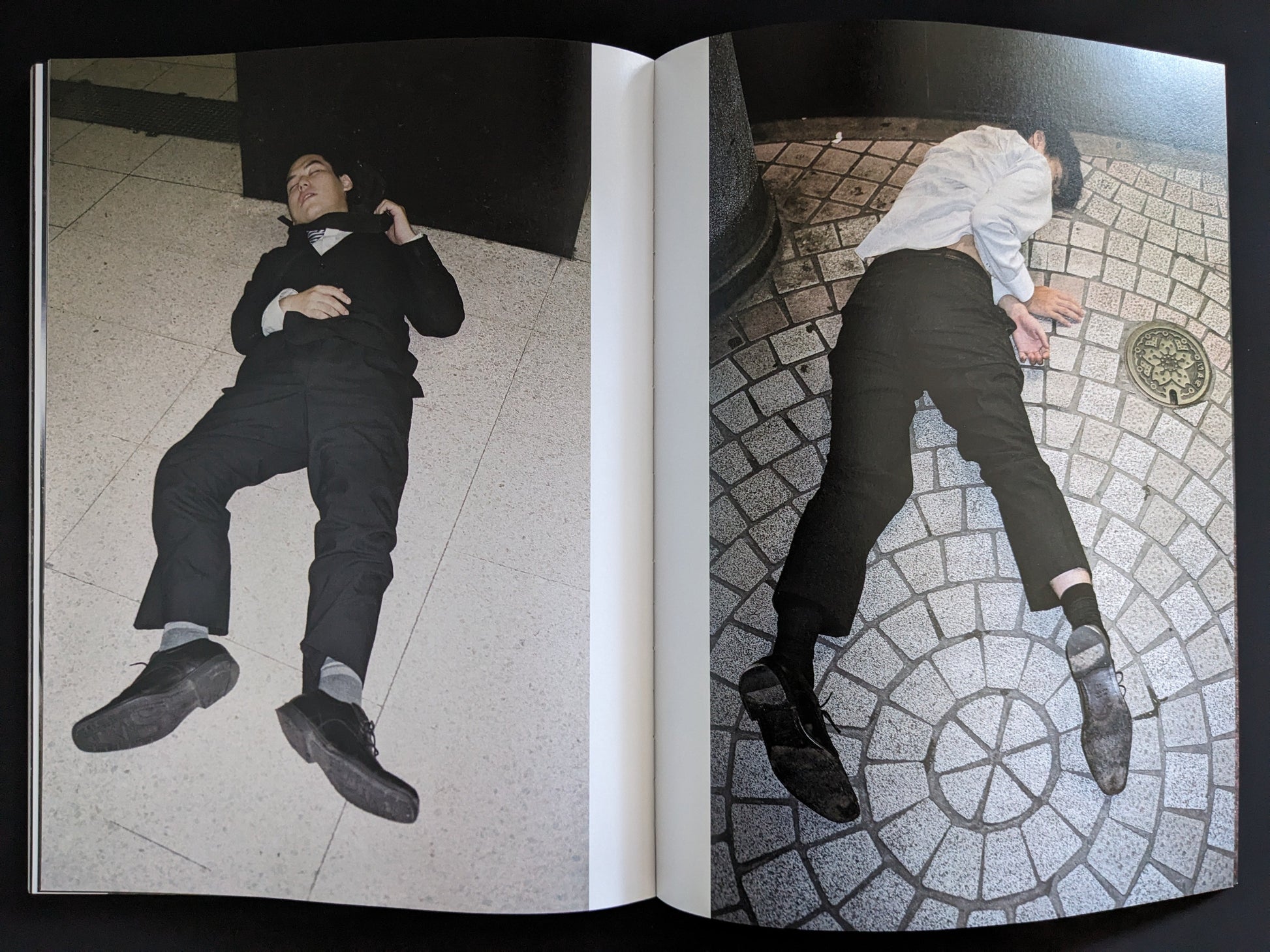 Open spread of businessmen lying on geometric tiled pavement at night