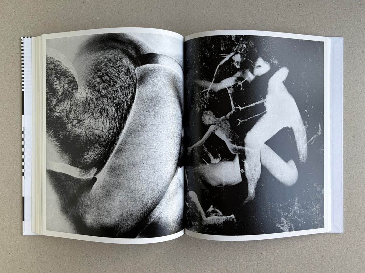 Homo Ludens open to a spread with blurred black-and-white nude studies
