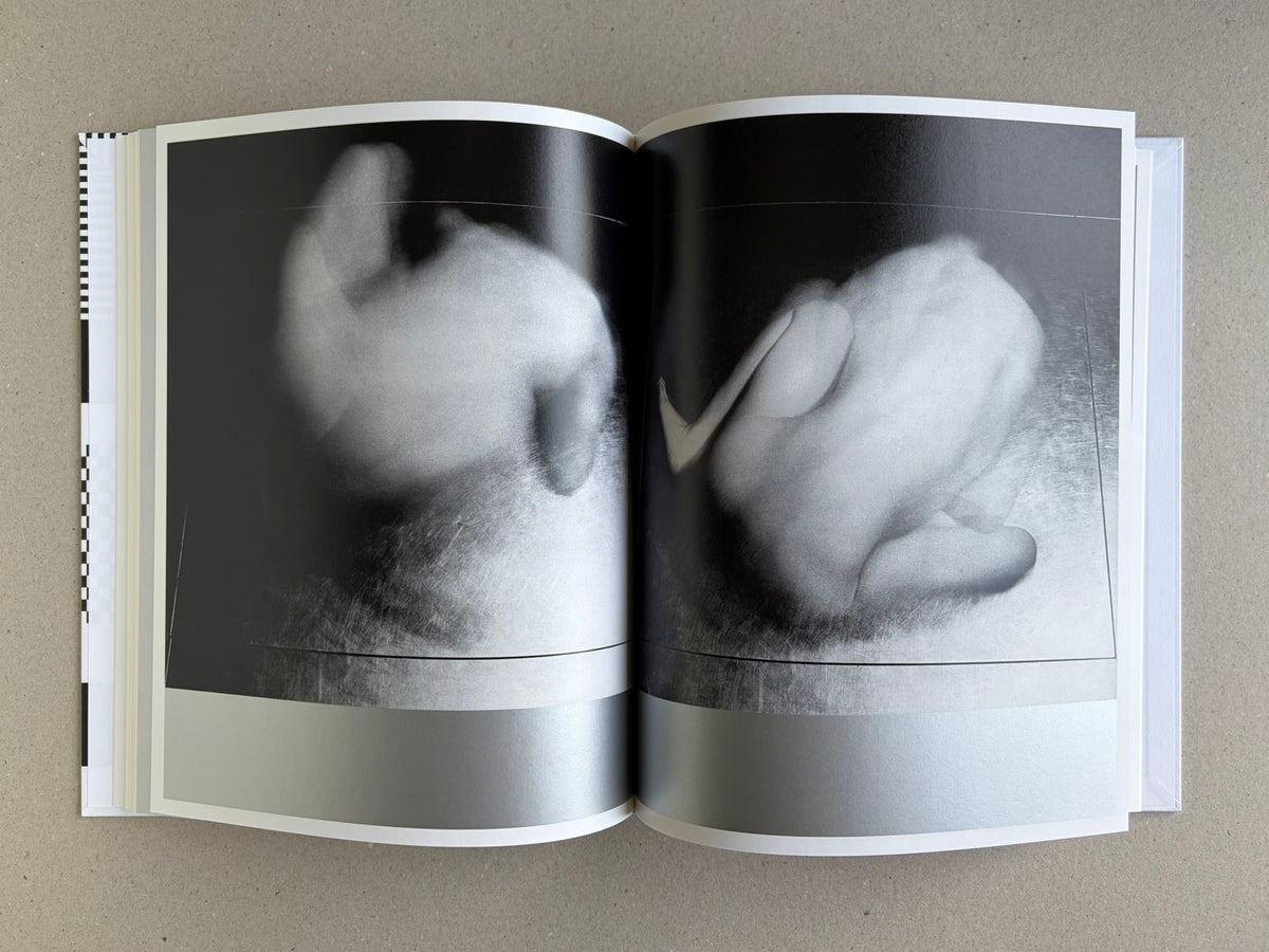 Homo Ludens open to a spread with two abstract black-and-white body studies