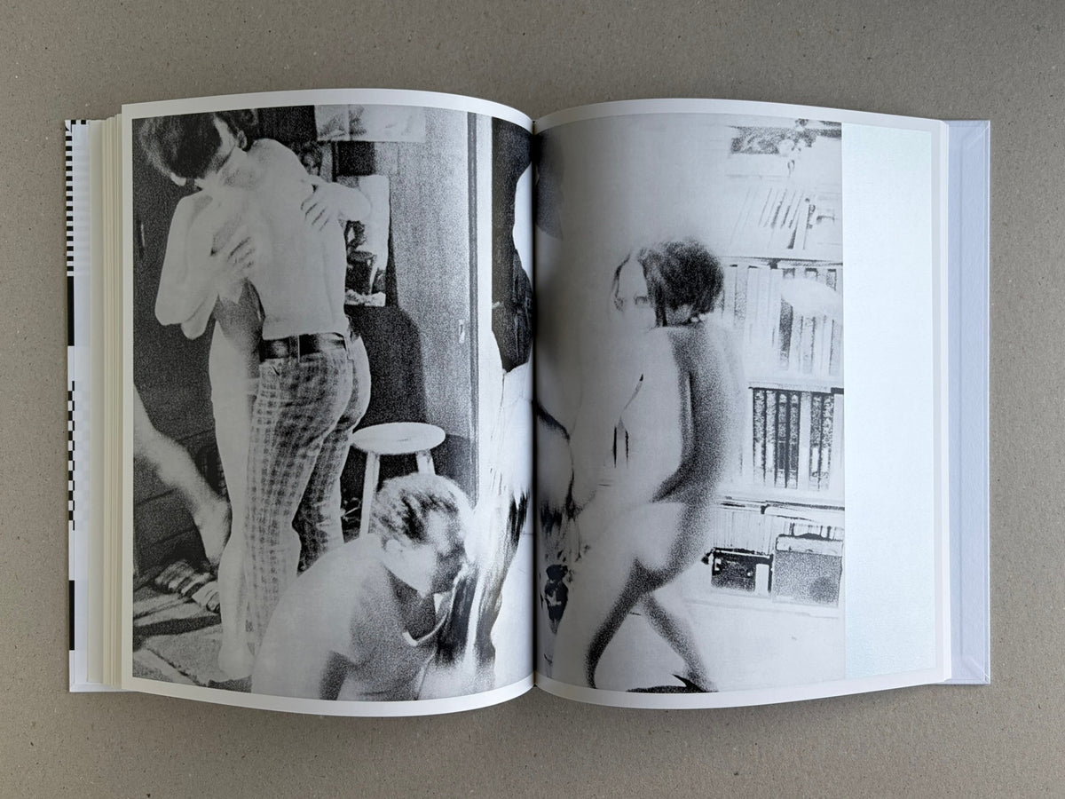 Homo Ludens open to a spread with blurred black-and-white figures in an interior