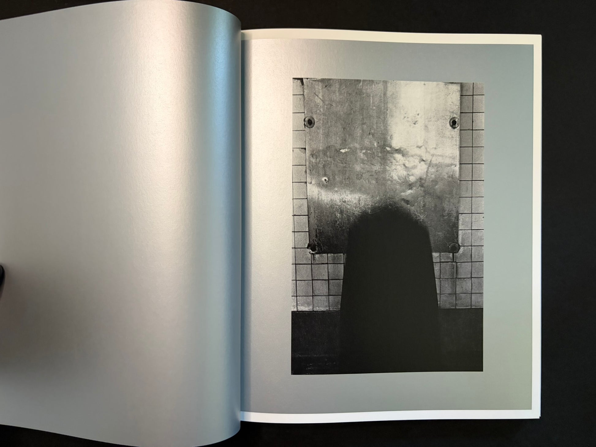 Open spread with a small black-and-white photograph on the right page and a blank left page
