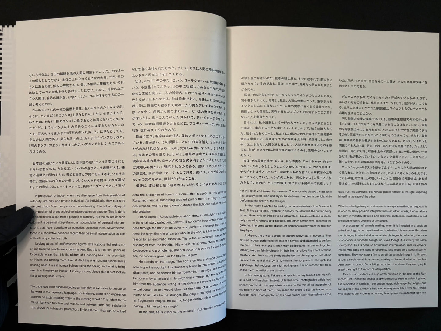 Open book showing Japanese and English text pages in Homo Ludens