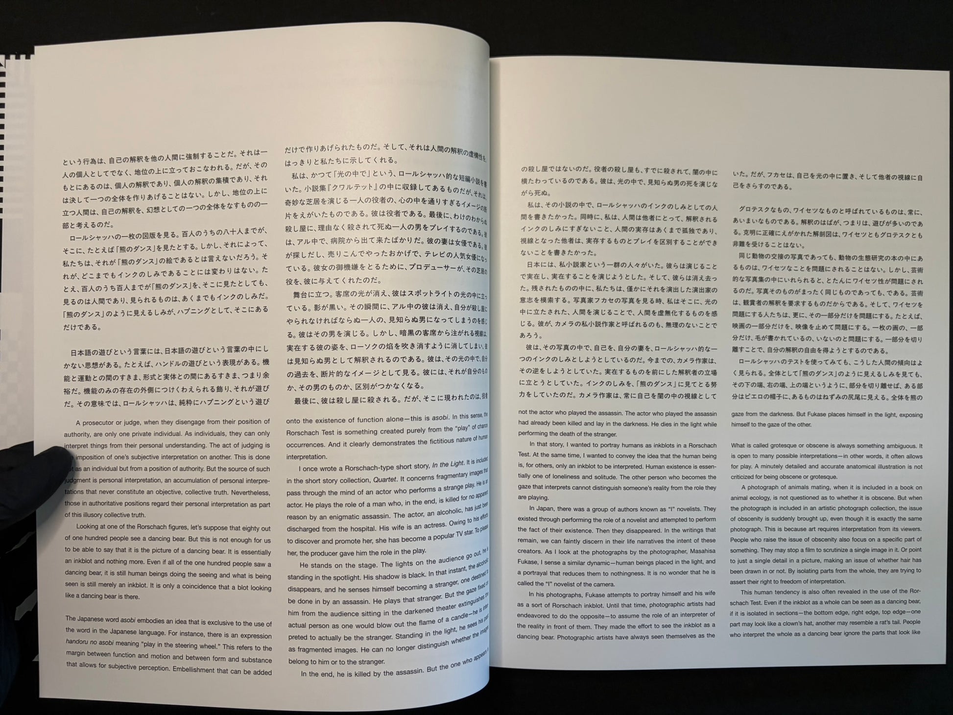 Open book showing Japanese and English text pages in Homo Ludens