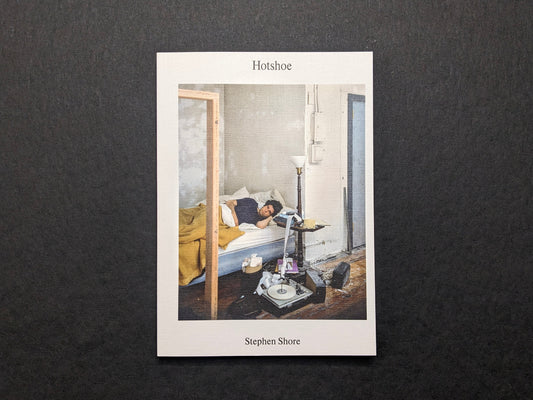 Cover of Hotshoe Issue 214 featuring a color photograph by Stephen Shore of a man lying on a bed in a sparse room.