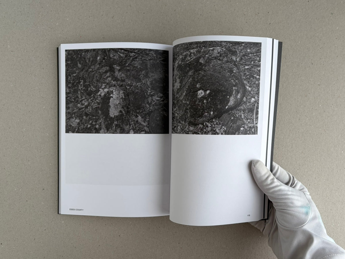 Open spread of Hotshoe Issue 214: Stephen Shore showing two black-and-white photographs of rocks and leaf litter, with a gloved hand holding the book open.