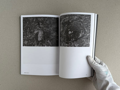 Open spread of Hotshoe Issue 214: Stephen Shore showing two black-and-white photographs of rocks and leaf litter, with a gloved hand holding the book open.
