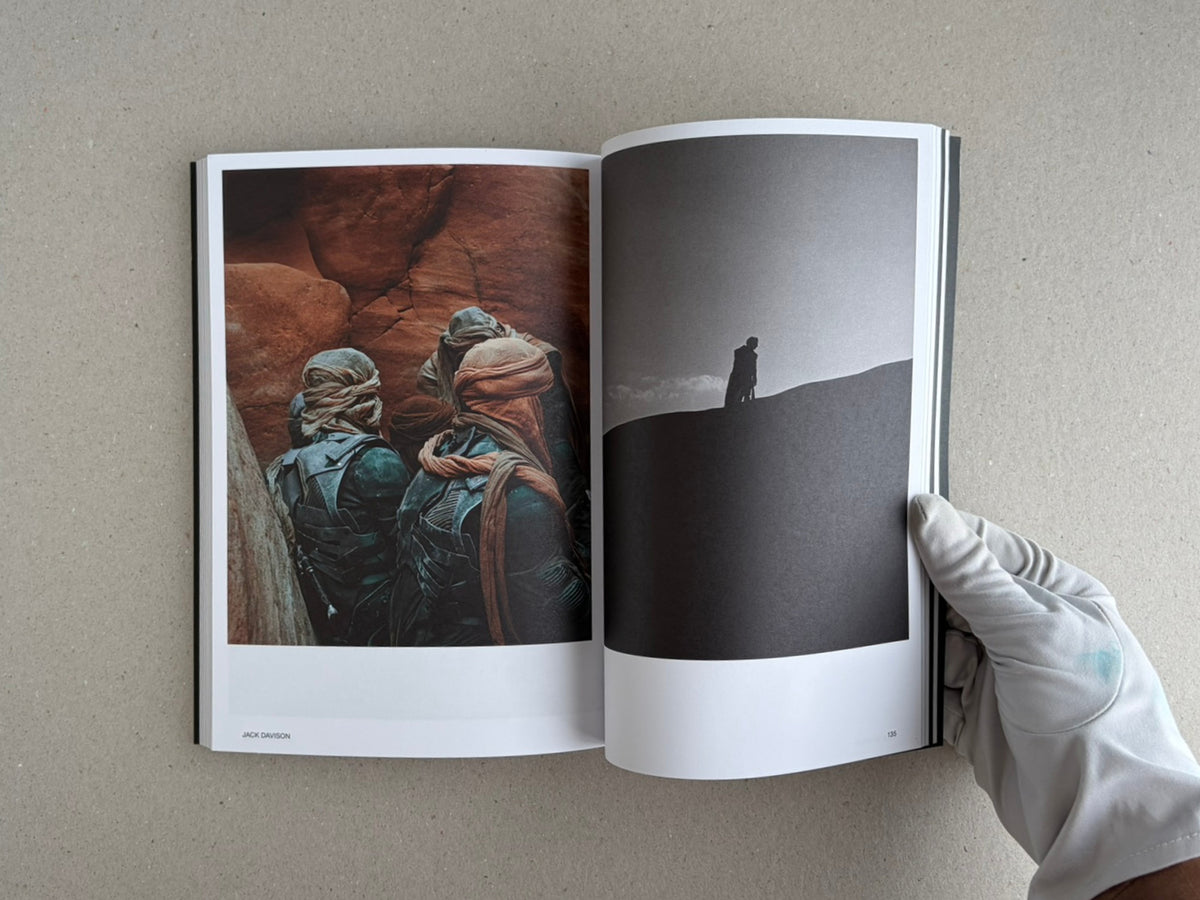 Open spread of Hotshoe Issue 215: At the Movies showing a colour film-set photograph on the left and a black-and-white silhouette on the right, held open by a gloved hand.