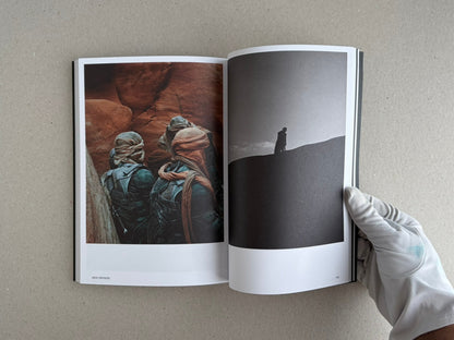 Open spread of Hotshoe Issue 215: At the Movies showing a colour film-set photograph on the left and a black-and-white silhouette on the right, held open by a gloved hand.