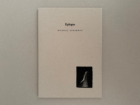 Front cover of Hunger: Epilogue by Michael Ackerman, showing a plain beige cover with the title and a small black-and-white image near the lower right.