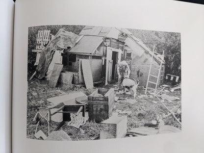 A child interacting with a goat beside a makeshift hut in Jongensland, surrounded by salvaged construction materials, captured by Ursula Schulz-Dornburg.