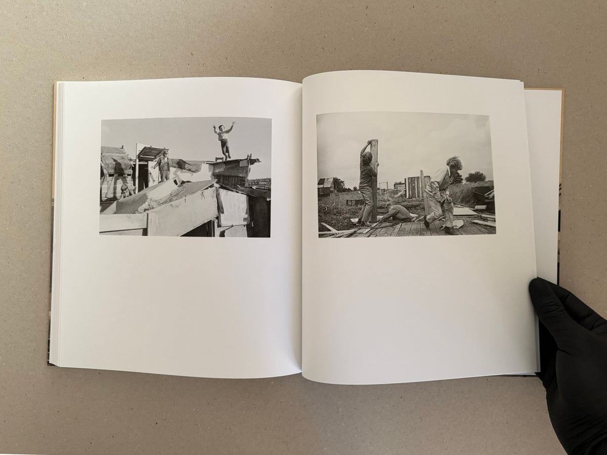 Open spread of Huts, Temples, Castles – Ursula Schulz-Dornburg, showing two black-and-white photographs of children building and standing among improvised structures.