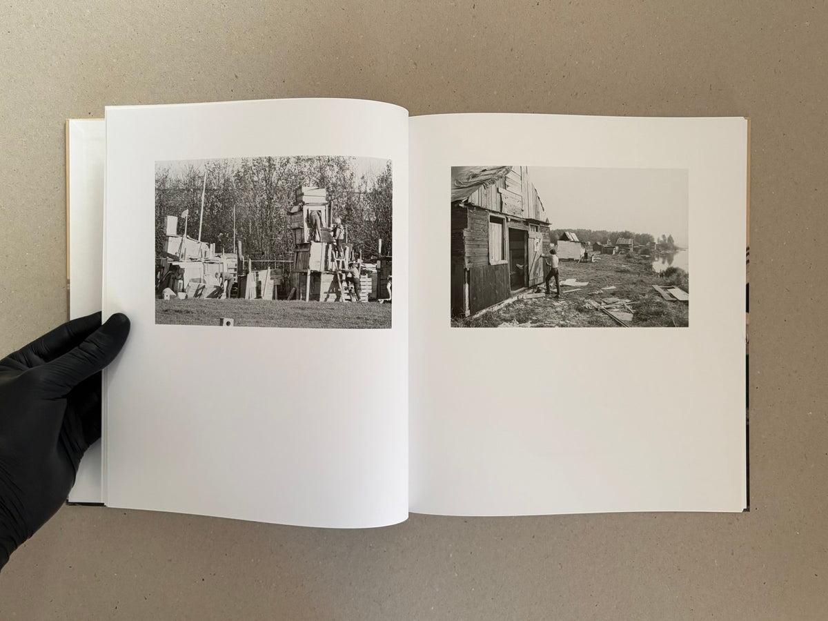 Open spread of Huts, Temples, Castles by Ursula Schulz-Dornburg, showing two black-and-white photographs of makeshift wooden structures and people working on them.