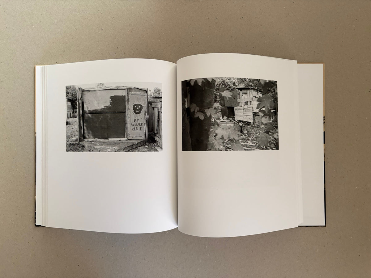 Open book spread from Huts, Temples, Castles by Ursula Schulz-Dornburg, showing two black-and-white photographs of improvised wooden structures on facing pages.