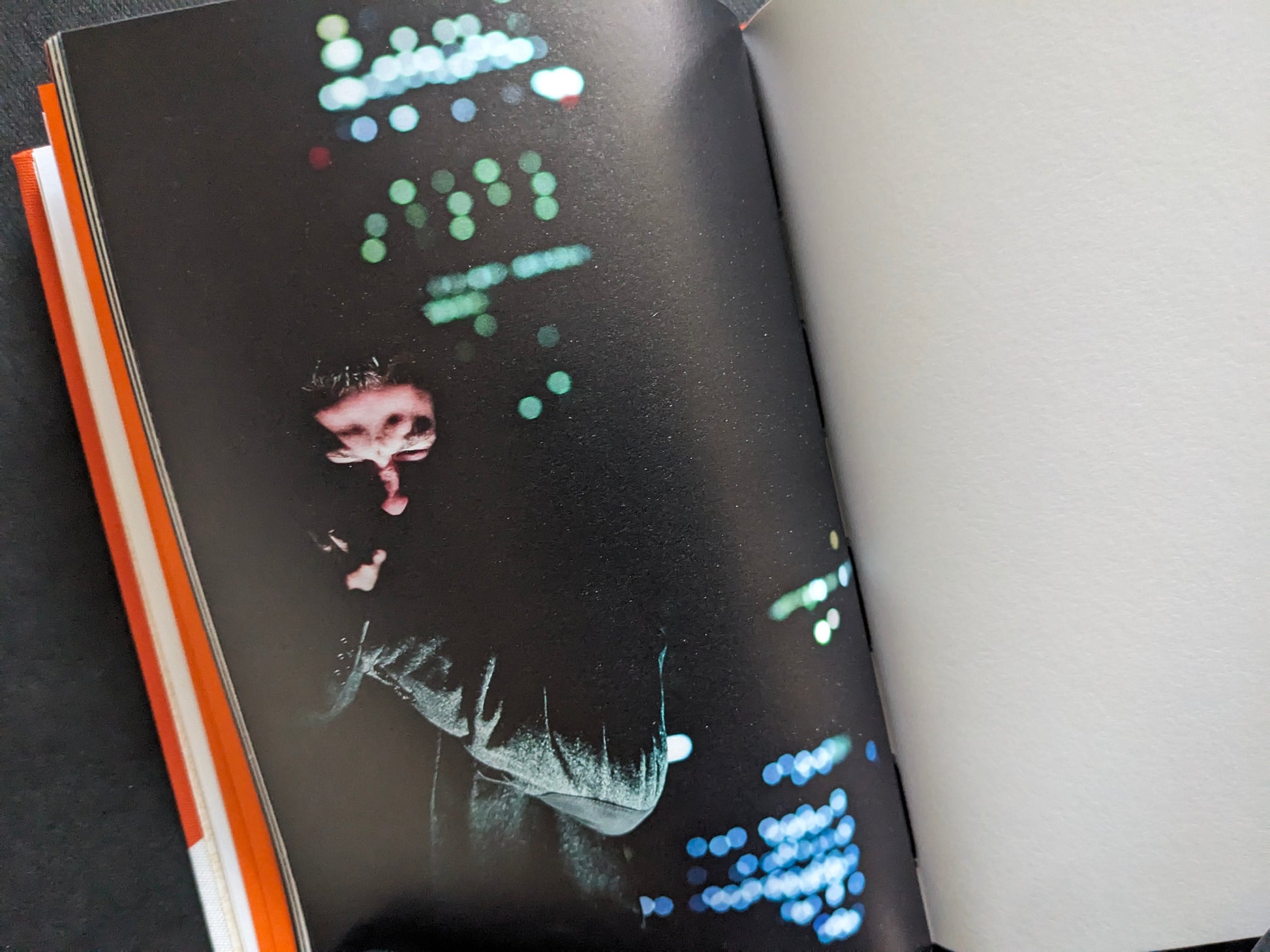 Dark portrait with blurred city lights in the background, from I’ll Bet The Devil My Head by Carlos Alba.