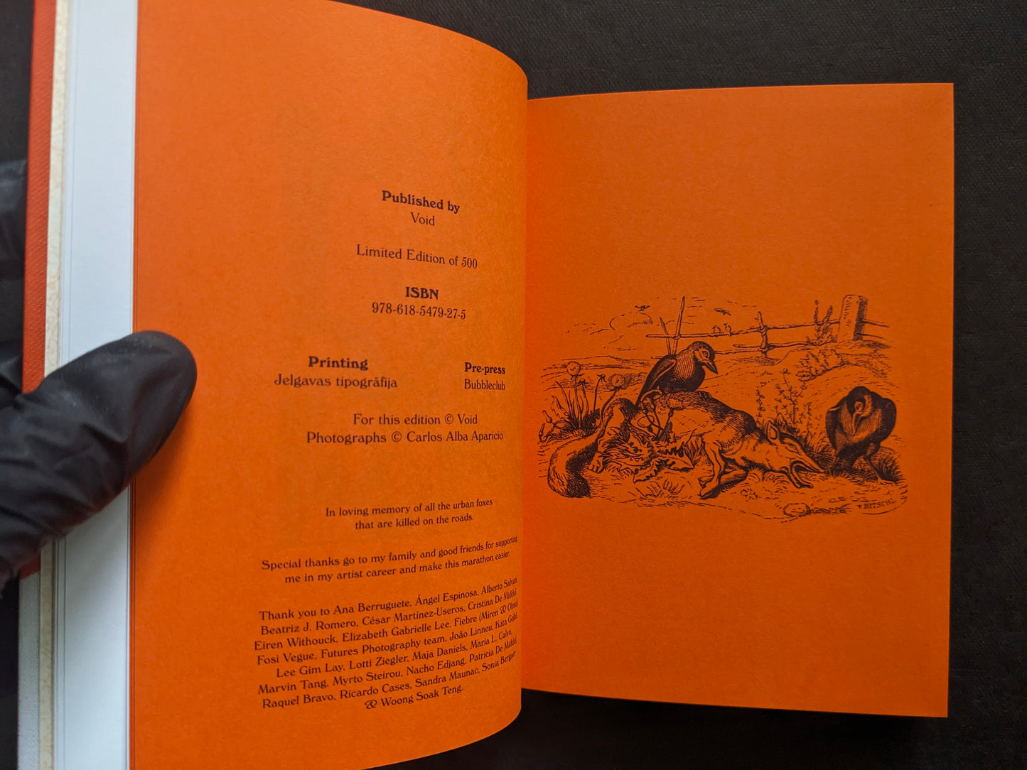 Colophon spread on orange paper with publication details and an illustrated scene.