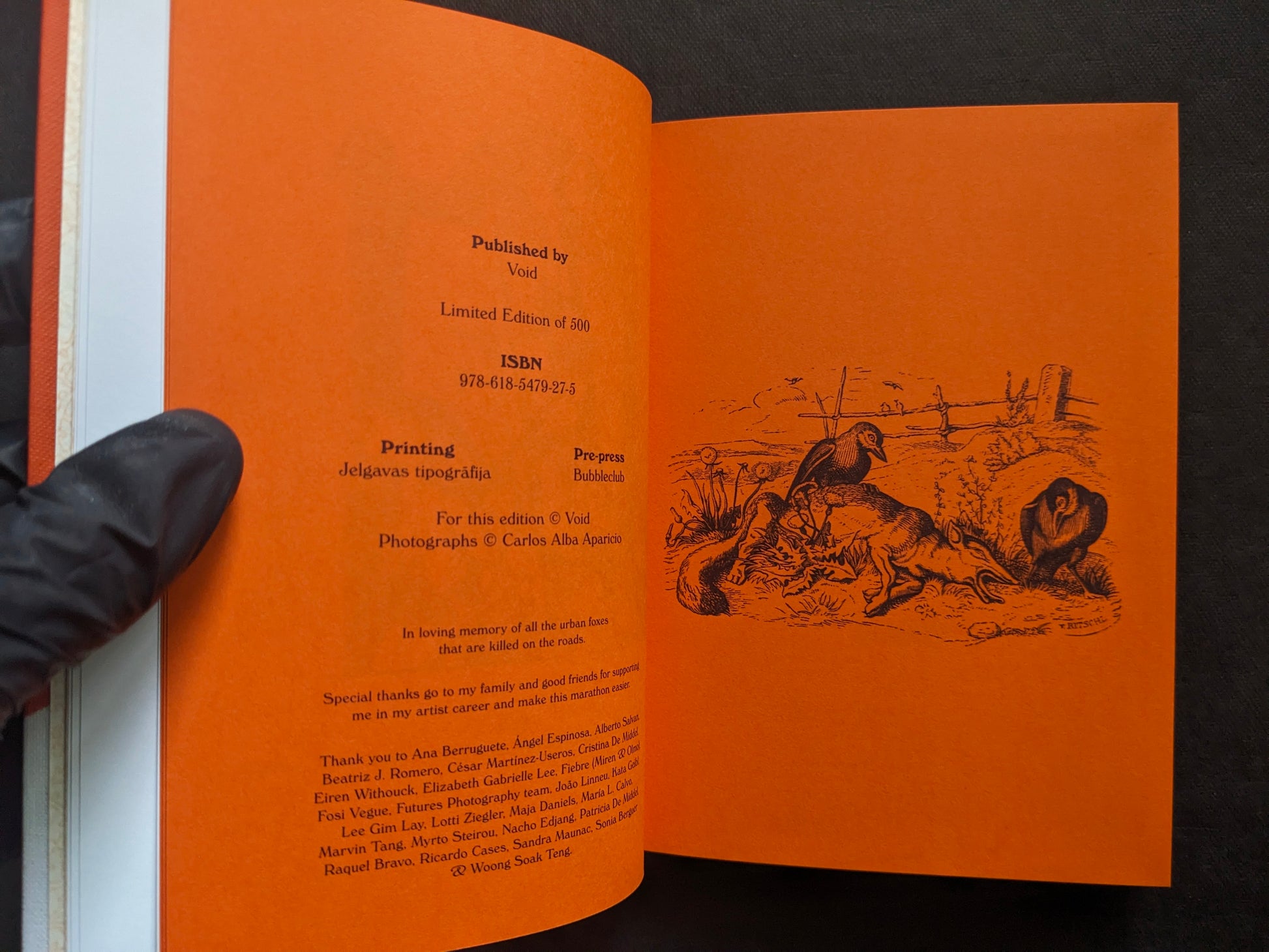 Colophon spread on orange paper with publication details and an illustrated scene.