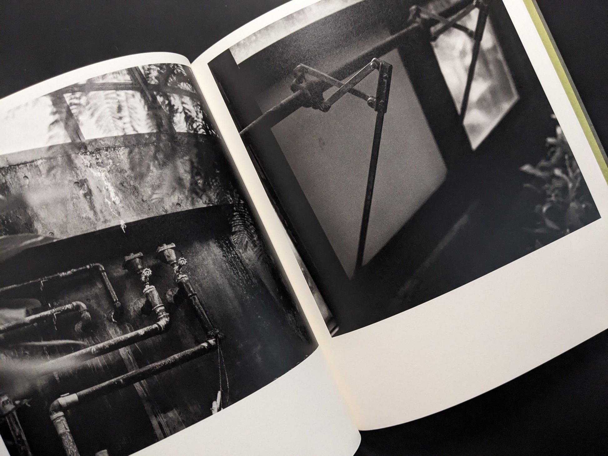 Industrial pipes and mechanical window opener inside a greenhouse, photographed in black and white by Takeshi Shinoda.