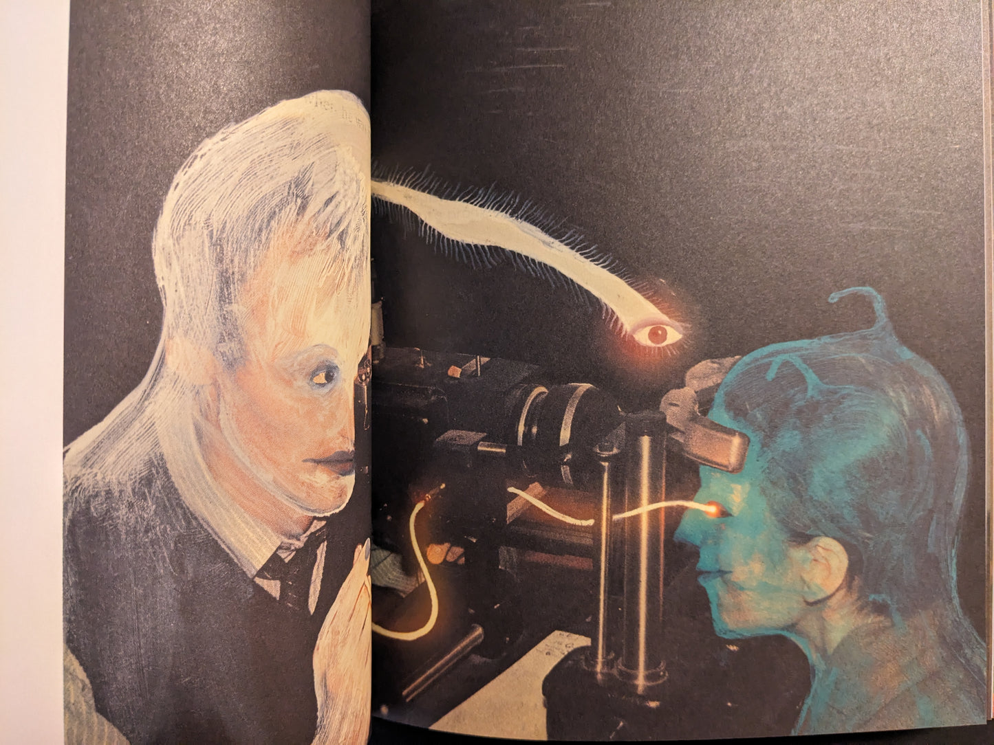 Interior double-page spread from In a Dark Time, the Eye Begins to See by Julia Soboleva, with two portraits facing a machine and a floating eye above.