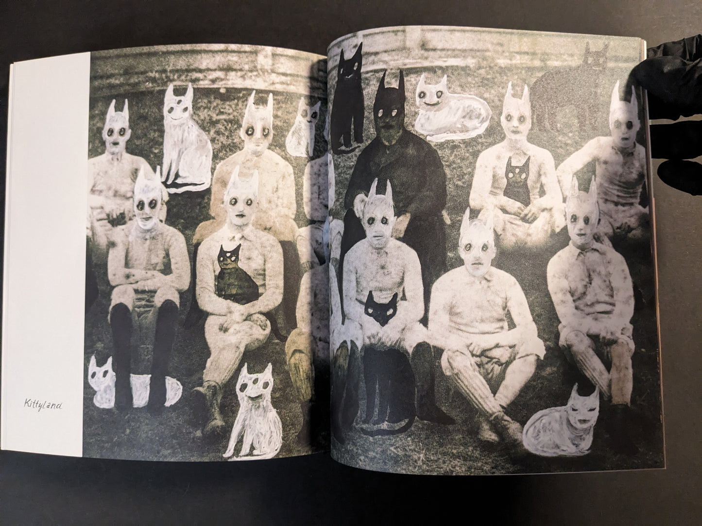 Interior spread showing a vintage-style group photo with cat masks and illustrated cats, captioned Kittyland.