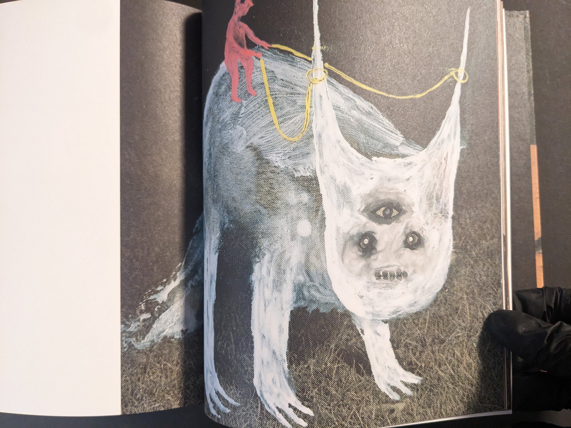 Interior artwork showing a pale multi-eyed creature hanging from ropes, with a small red figure above.