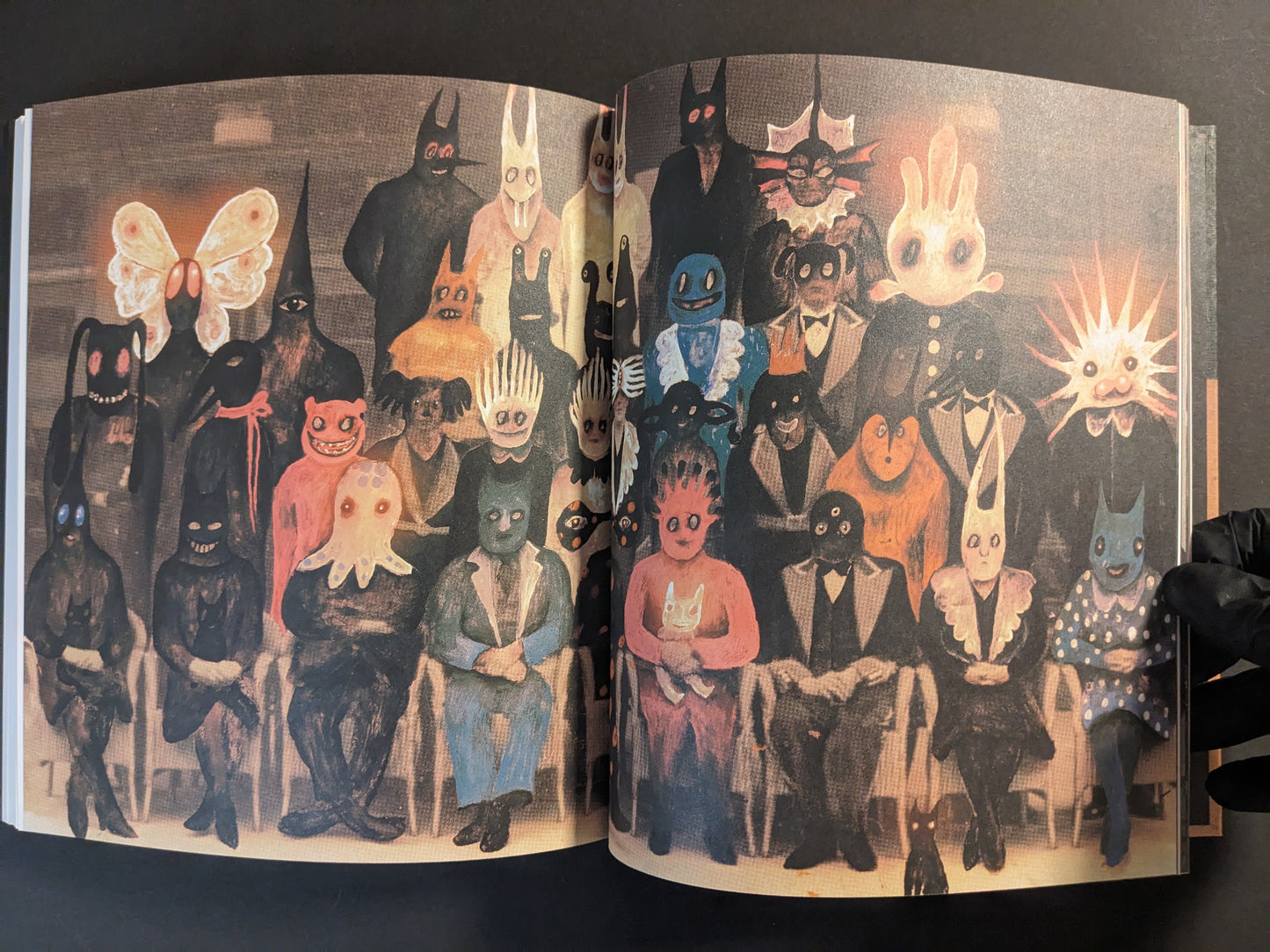 Interior spread showing a group portrait of masked figures in formal clothing.