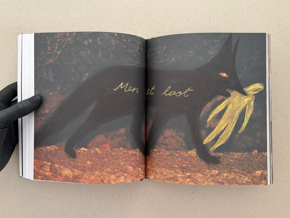Open spread from In a Dark Time, the Eye Begins to See – The Art of Julia Soboleva, showing a dark animal figure with a glowing eye and yellow painted marks across the page.