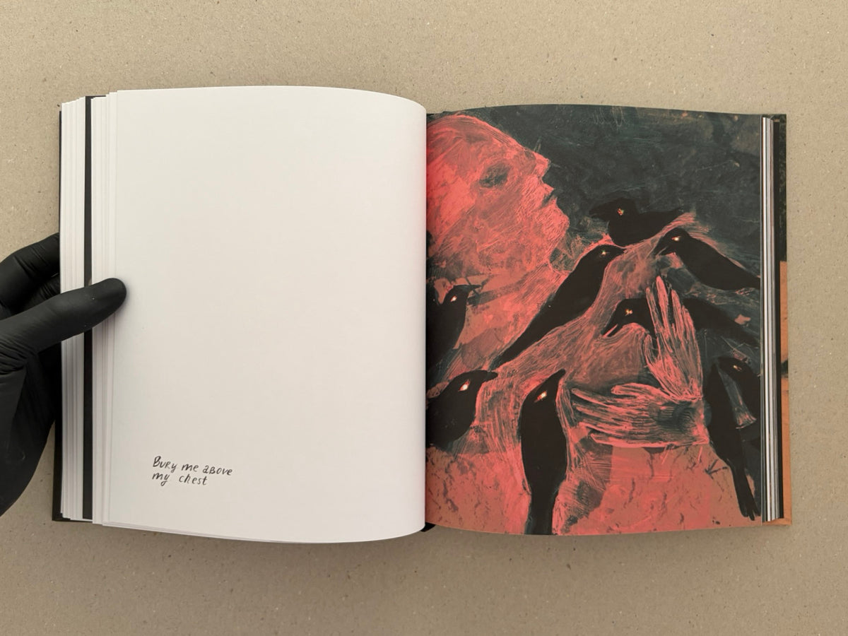 Open artbook spread from In a Dark Time, the Eye Begins to See – The Art of Julia Soboleva, showing a blank left page with handwritten text and a right page with a red-and-black mixed-media image.