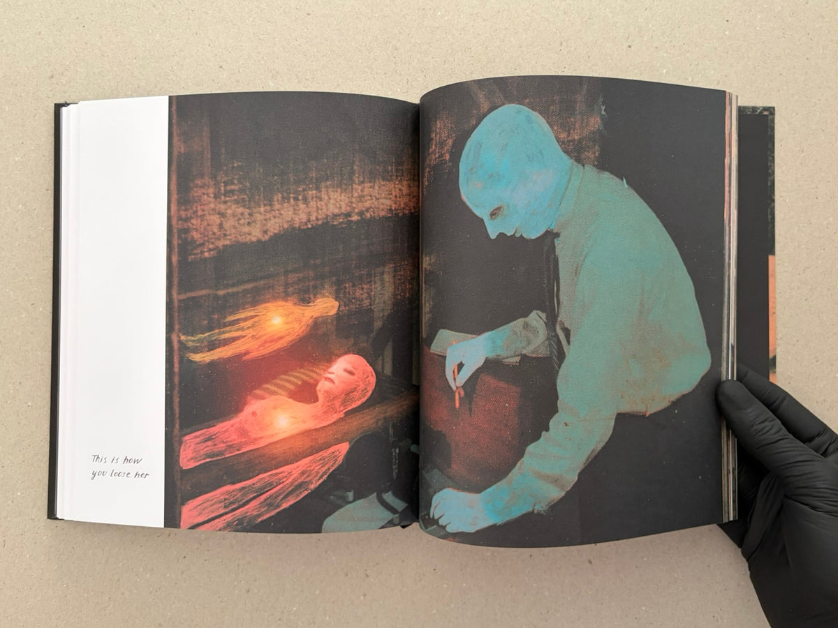 Open spread from In a Dark Time, the Eye Begins to See – The Art of Julia Soboleva, showing a dark mixed-media image on the left page and a turquoise figure on the right page.