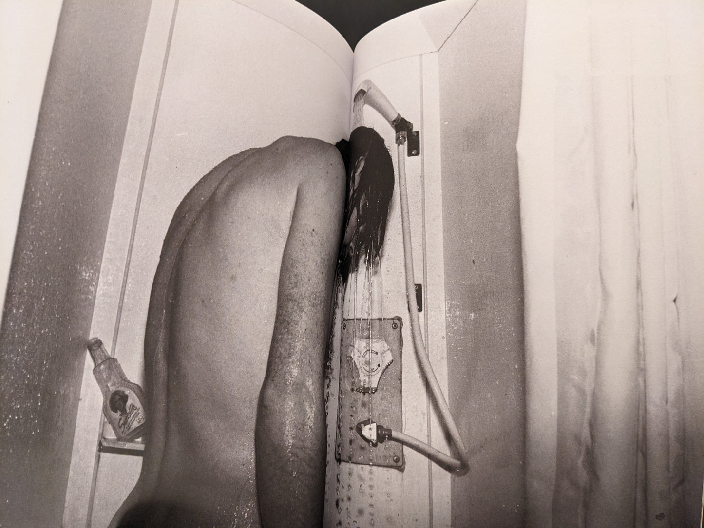 Black-and-white photograph of a person showering, from the concluding section of In Steel Grey Armour.