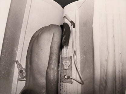 Black-and-white photograph of a person showering, from the concluding section of In Steel Grey Armour.
