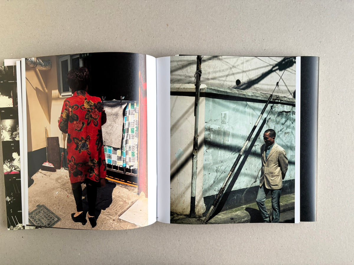 Open Index — Christopher Anderson booklet with a two-page spread of colour photographs, including a person in a red coat and a man standing by a wall.
