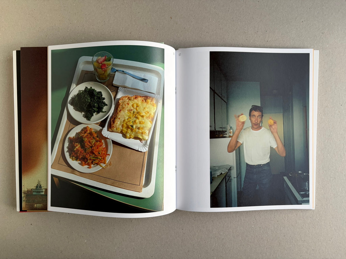 Open Index — Christopher Anderson booklet with a tray of food on the left page and a man holding fruit on the right page.