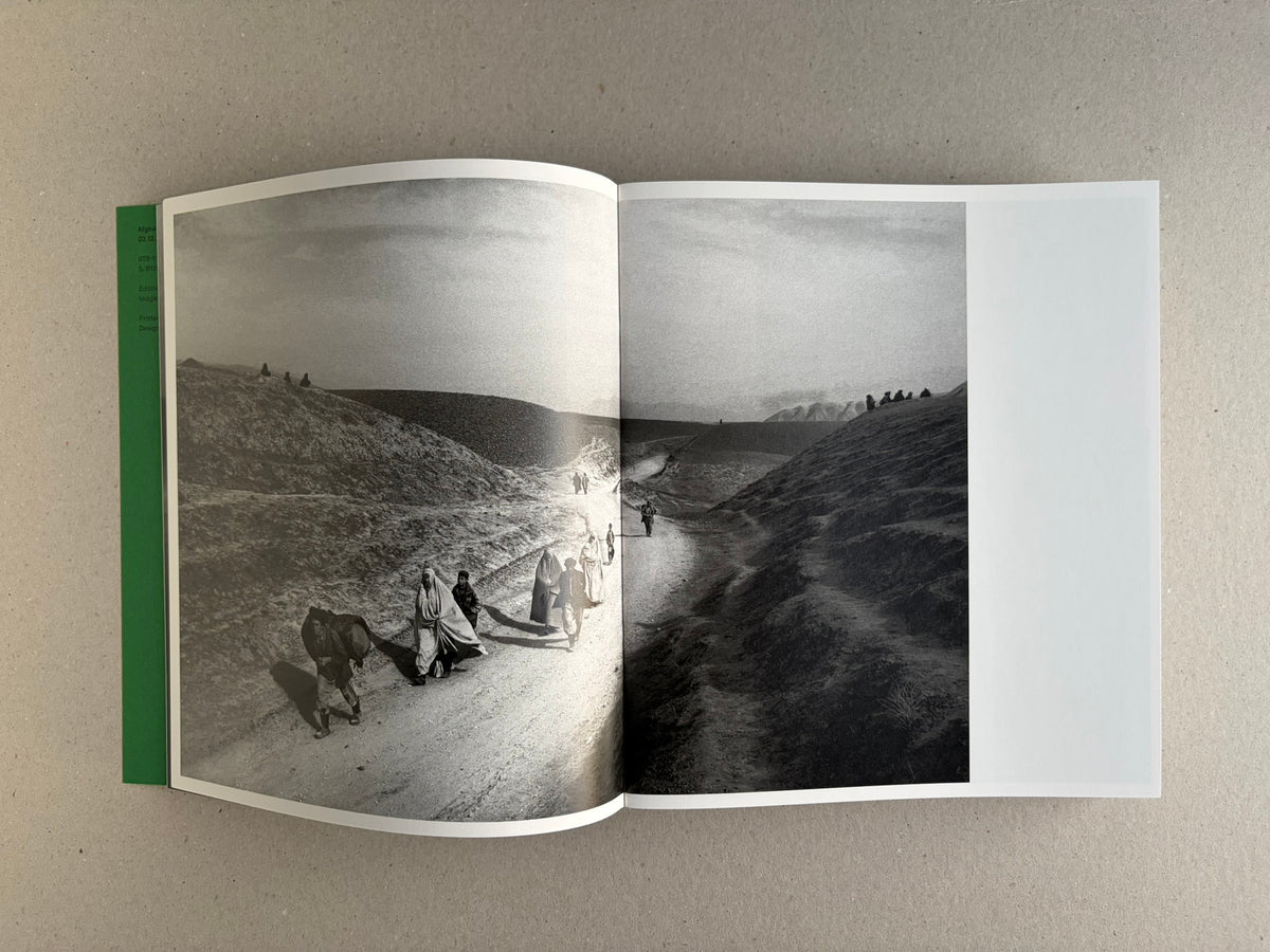 Open Index — Christopher Anderson booklet with a full-bleed black-and-white spread of figures walking through a barren landscape.
