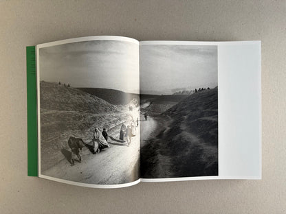 Open Index — Christopher Anderson booklet with a full-bleed black-and-white spread of figures walking through a barren landscape.
