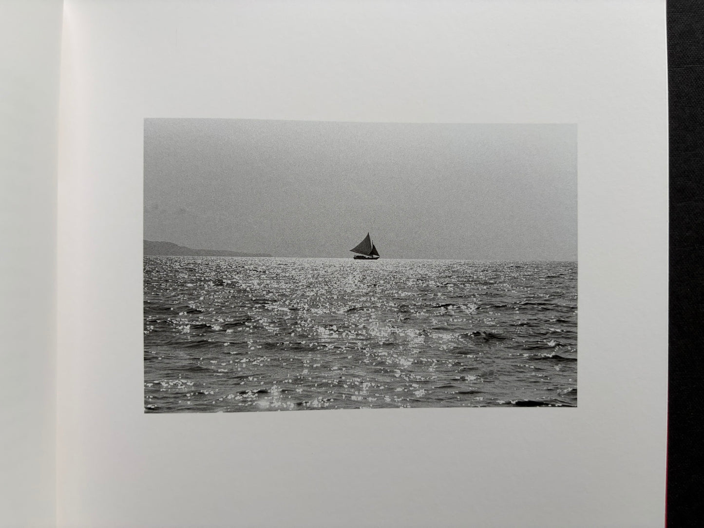 Index by Christopher Anderson, black-and-white seascape with a small sailboat near the horizon.