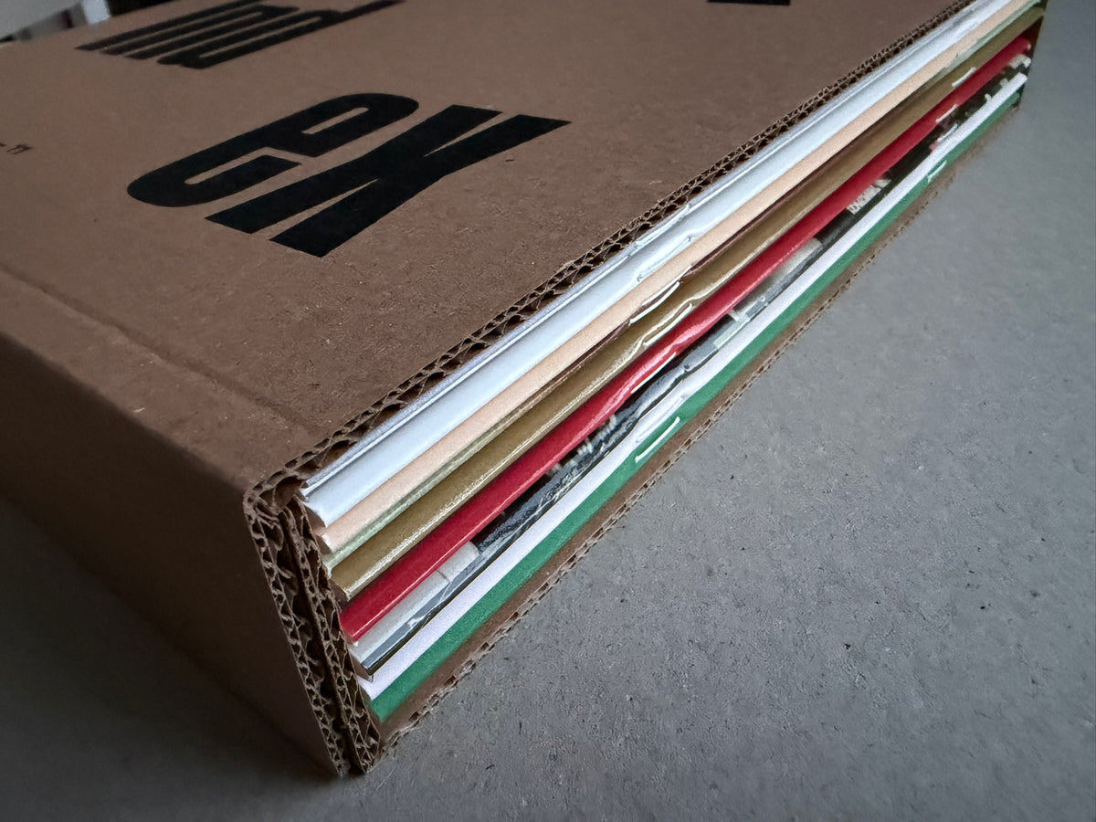 Index — Christopher Anderson slipcase edge, showing stacked booklet spines and exposed cardboard layers.
