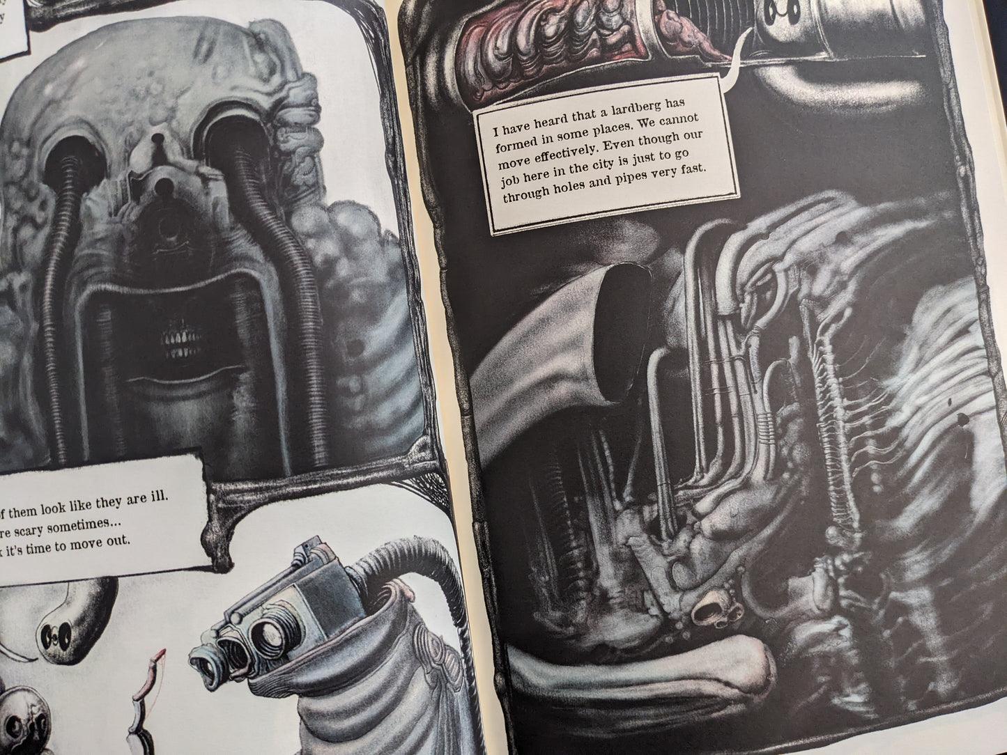 Open spread with a skull-like face, a dog figure, and dense biomechanical textures in black and white.