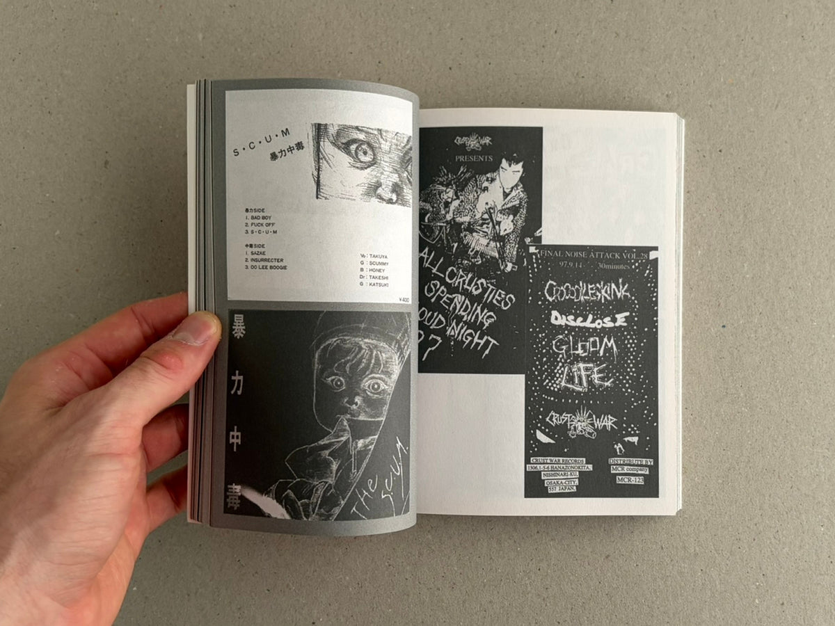 Open book spread showing black-and-white punk graphics and Japanese text, held open by a hand