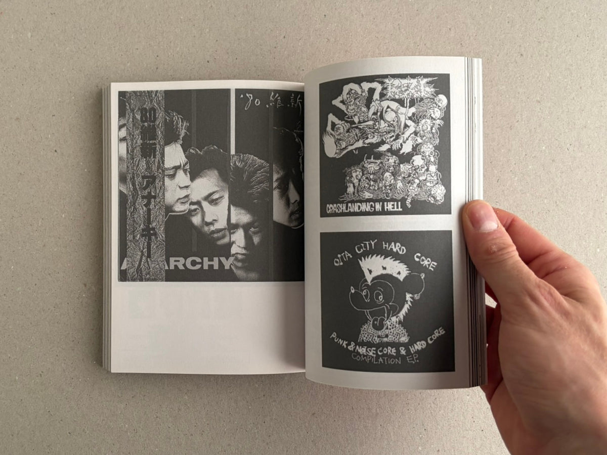 Open book showing black-and-white punk graphics on two pages, with a hand holding the right side.