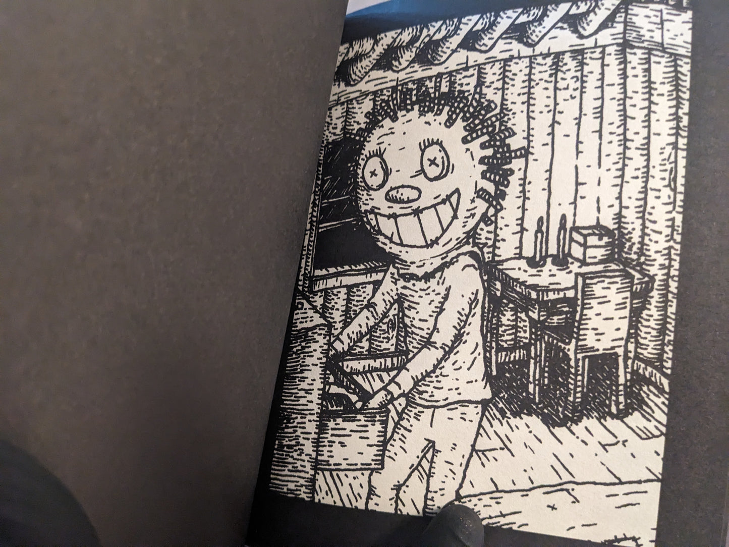Interior artwork showing a grinning figure inside a wooden cabin.