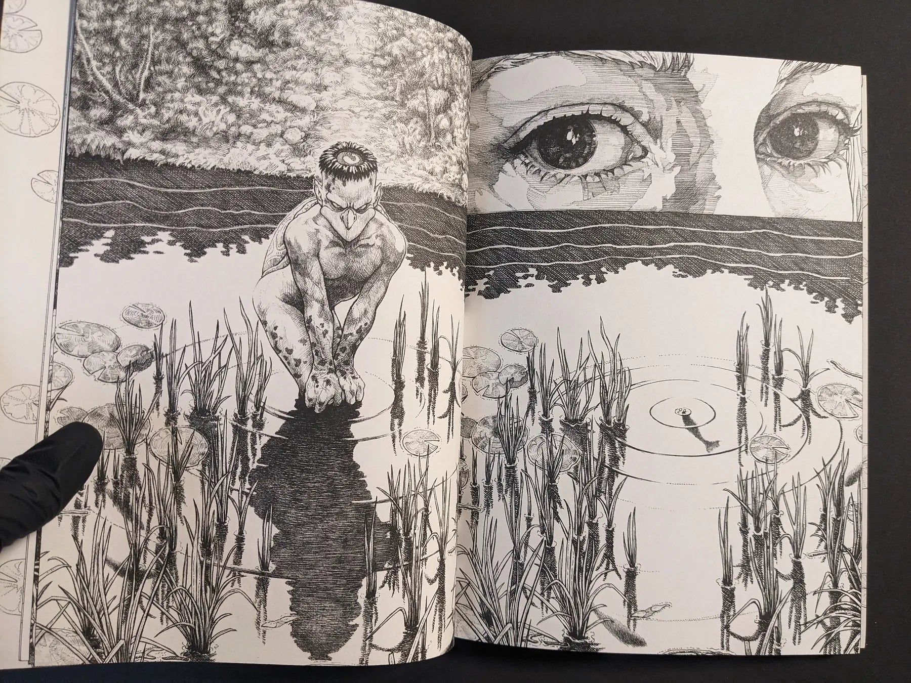 Interior spread with a kappa-like figure by water and large eyes above the horizon, black-and-white ink