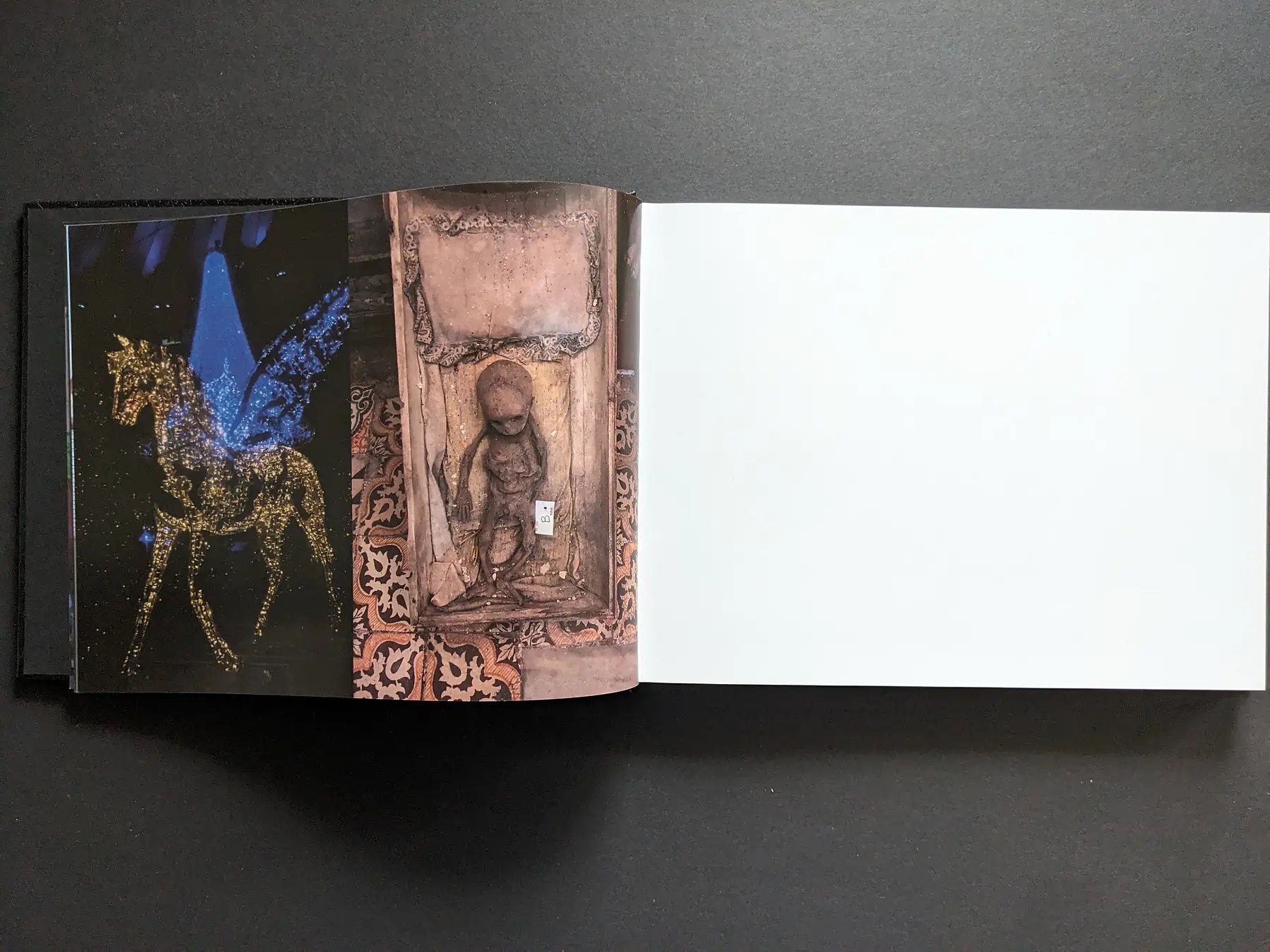 Interior spread showing a glittering winged horse on stage beside a small carved child figure in a niche.