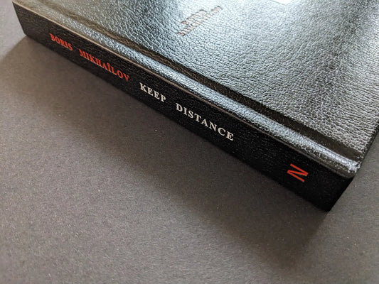 Spine of the black hardcover photobook Keep Distance by Boris Mikhailov.