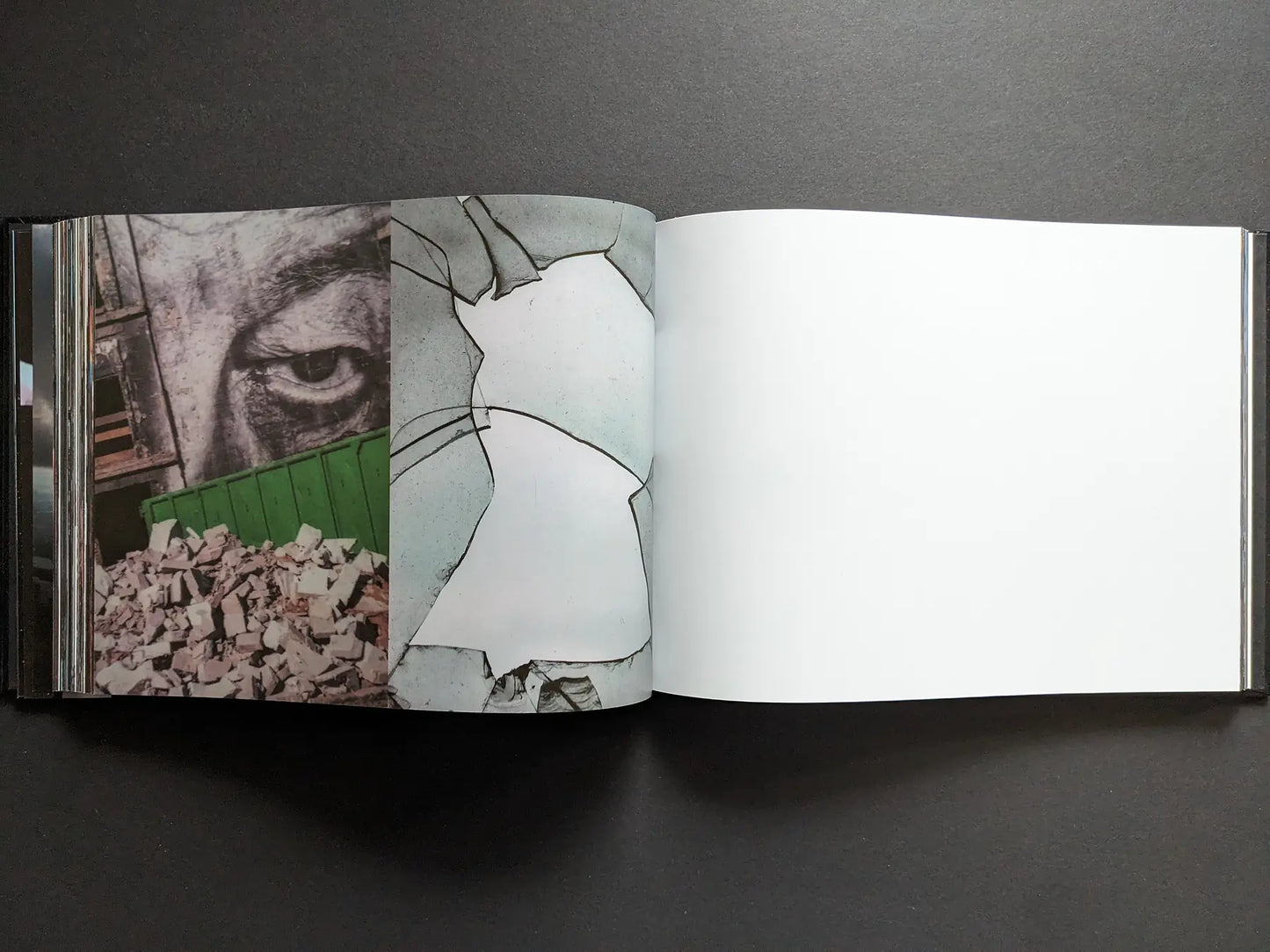 Close-up of an eye painted on a wall above rubble and an abstract cracked surface, with blank page, in Boris Mikhailov’s Keep Distance.