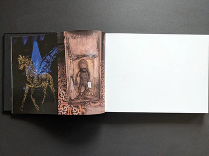 Interior spread from Keep Distance showing a glittering winged horse on stage beside a photograph of a small carved child figure in a niche.