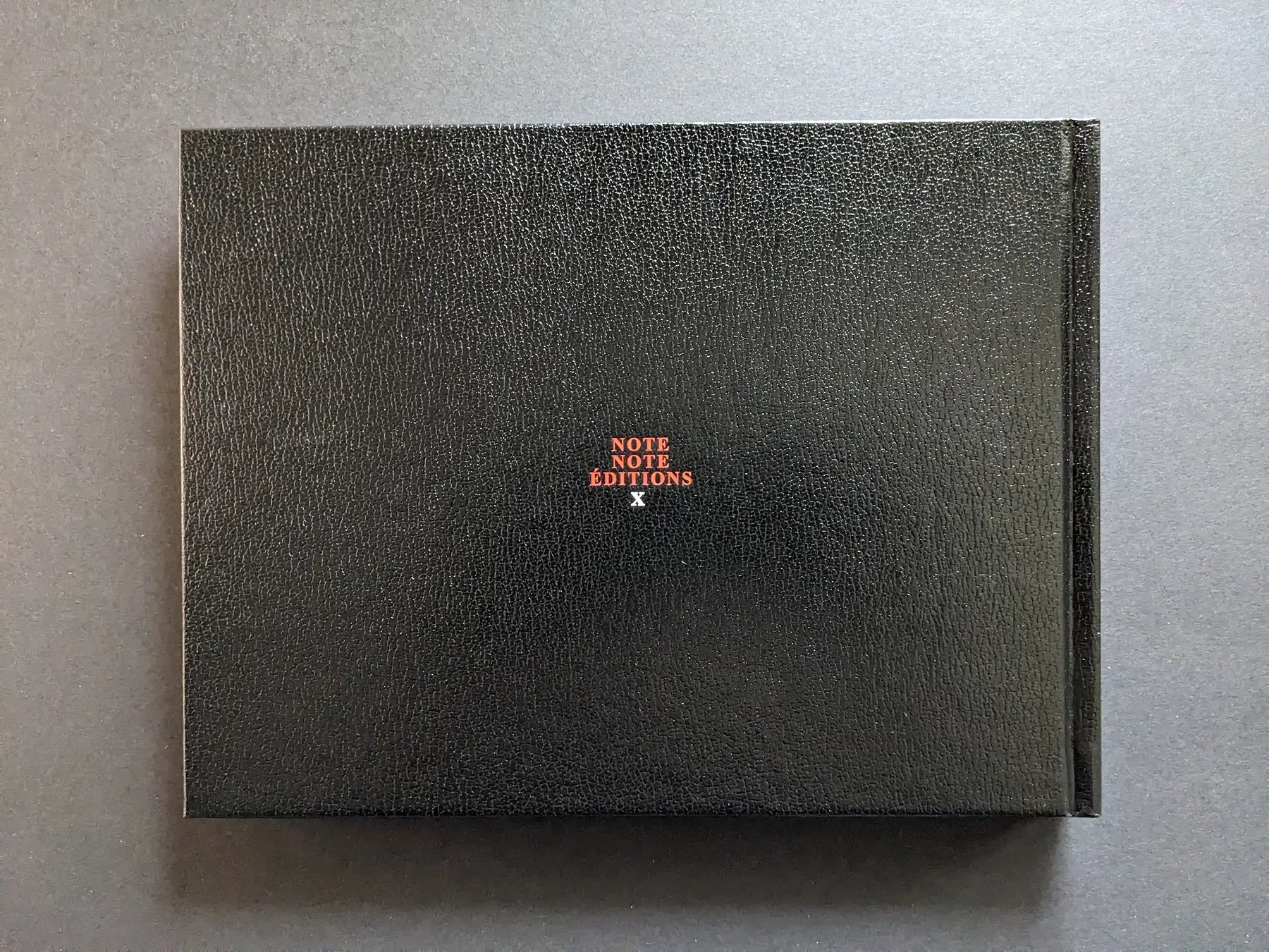 Back board of Keep Distance photobook by Boris Mikhailov, black faux-leather cover with small Note Note Éditions logo.