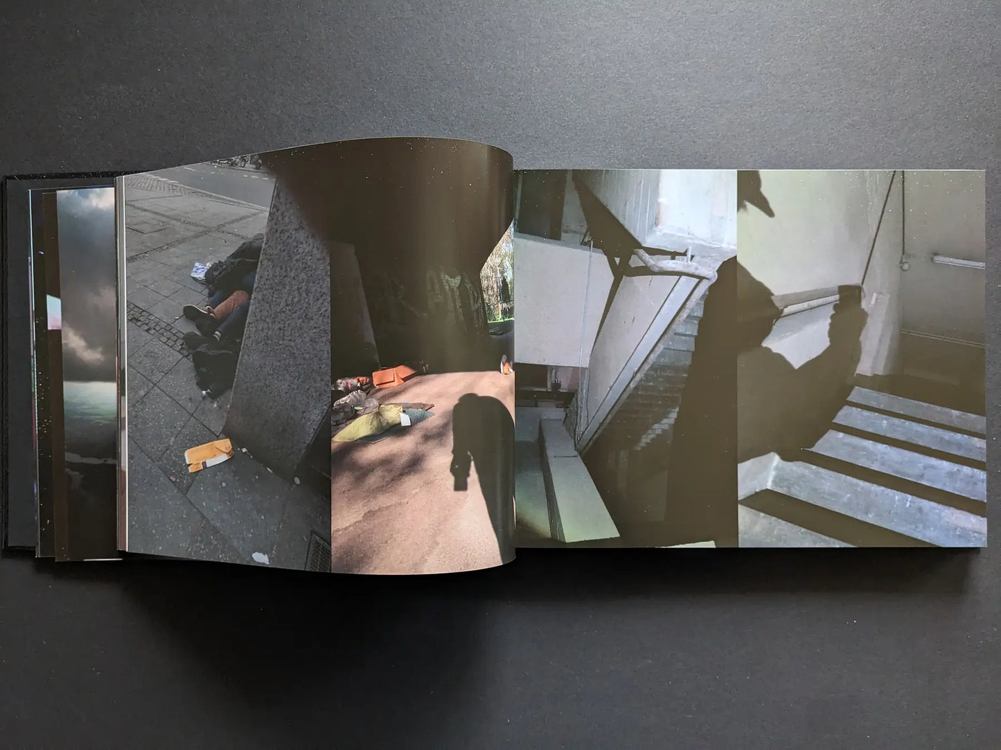 Interior spread from Keep Distance with colour photographs of people sleeping rough in the city, an underpass, and a silhouetted figure on stairs.