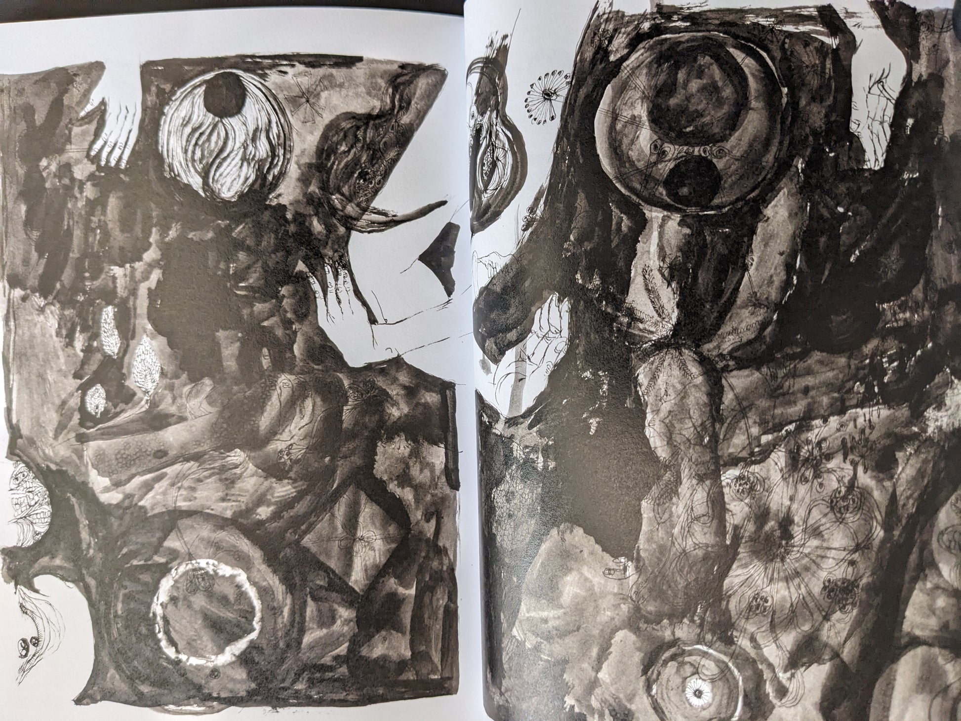 Abstract spread from "KSKHH" by Daisuke Ichiba featuring dark surreal imagery and organic textures